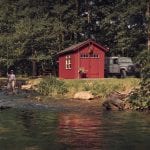 Red fishing shed on a lake.
