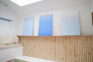 Shed detail: Wood paneled wall and blue sky paintings.