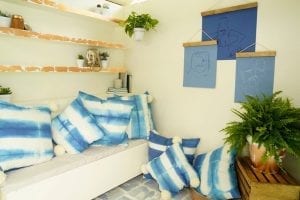 Shed detail: Couch with blue throw pillows. Blue wall art hanging.