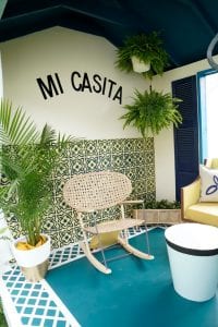 Shed detail: Rocking chair with letters on wall that say "Mi casita."