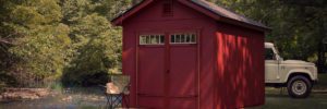 Red wood shed with camping chair in front.