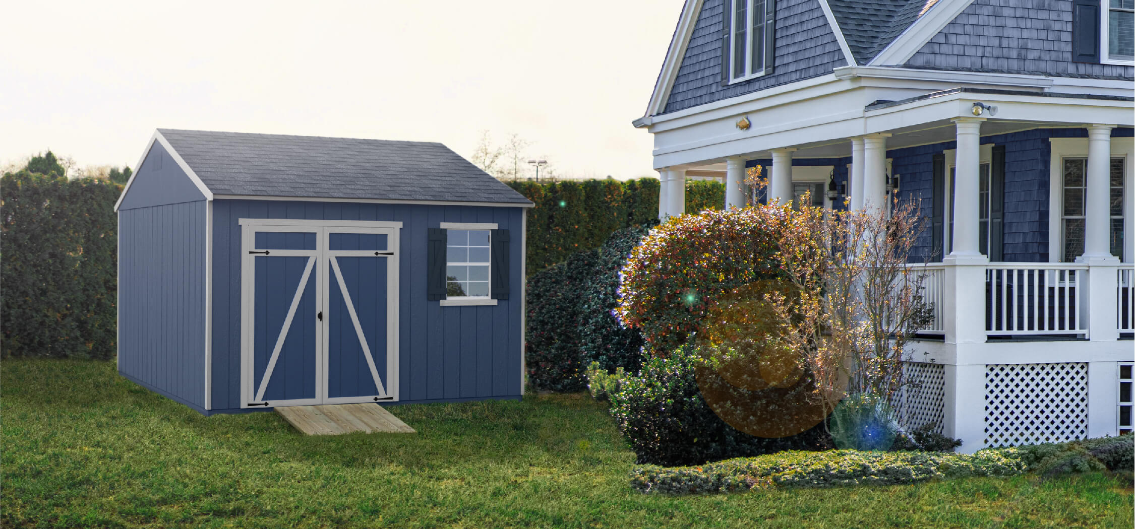 Shed next to house painted to match - blue siding, white shingles, and dark blue shutters.